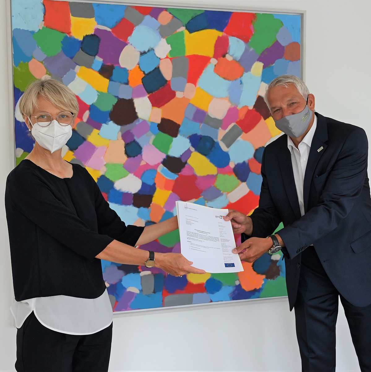 Regierungspräsidentin Dorothee Feller (links) überreicht den Förderbescheid an Bürgermeister Wilhelm Sendermann (rechts); Foto: Bezirksregierung Münster